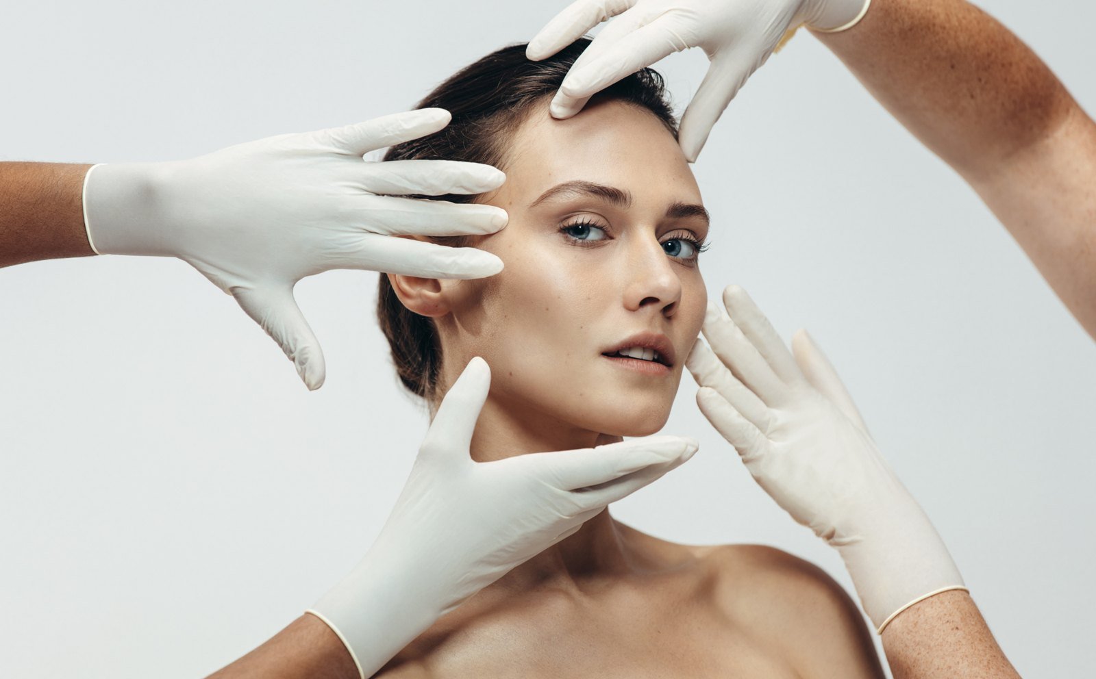 Professionele huidanalyse met handschoenen tijdens een medisch-esthetische gelaatsbehandeling